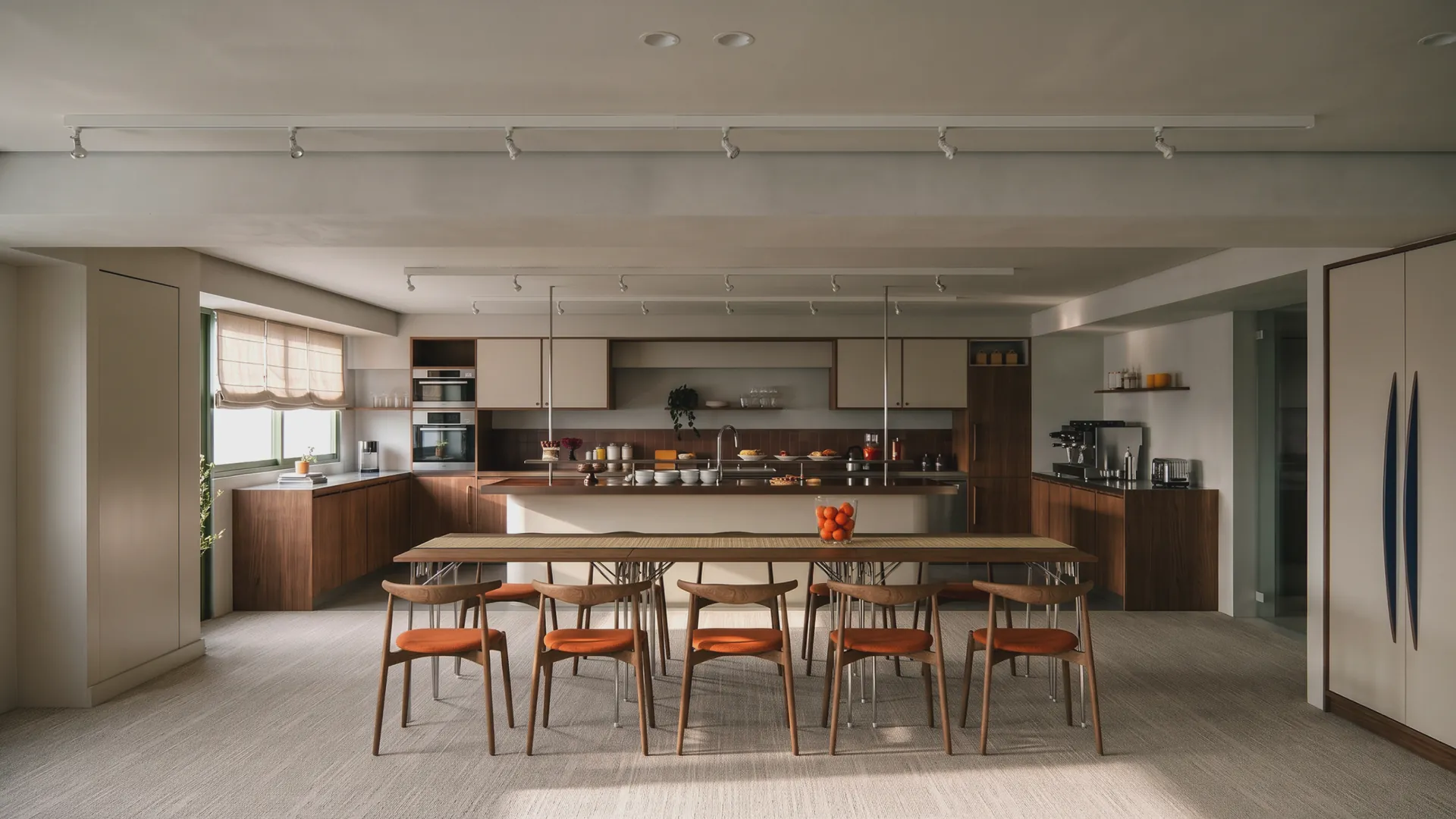 The kitchen: a long table with rust chairs in front of an open kitchen